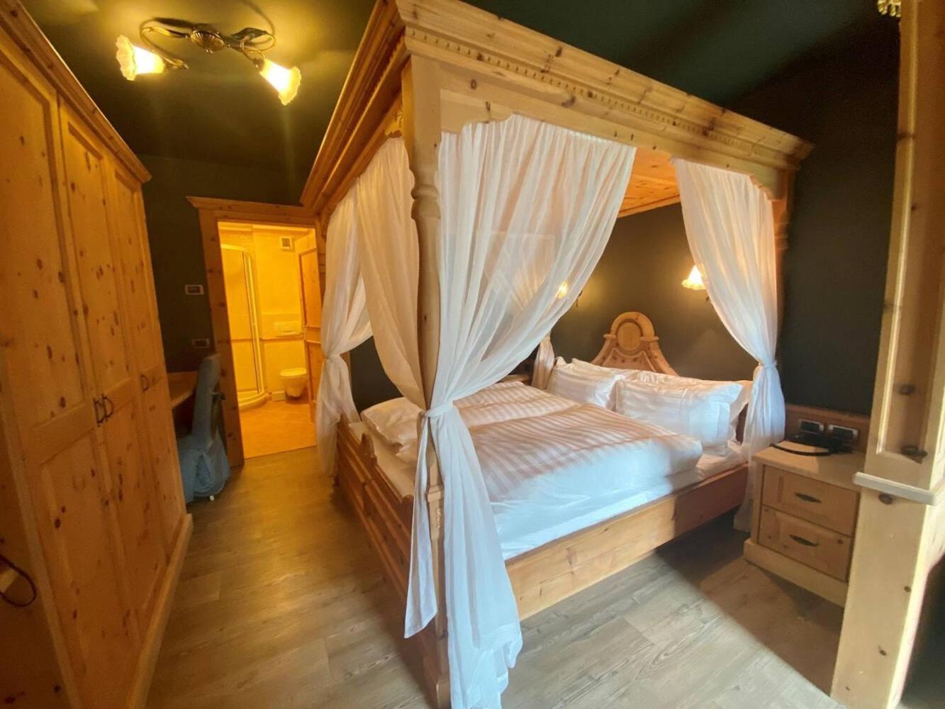 Hotel Chalet Al Foss Vermiglio Esterno foto A four-poster bed